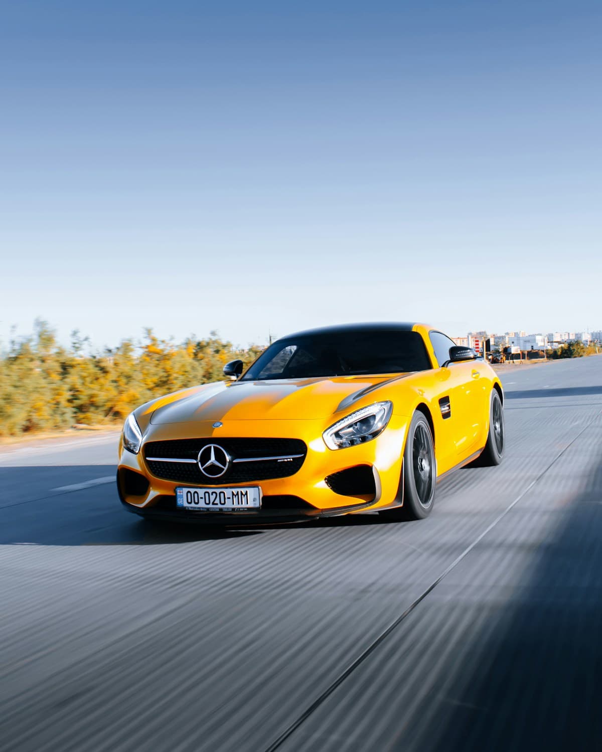 Mercedes-AMG GT amarillo circulando sobre una carretera despejada